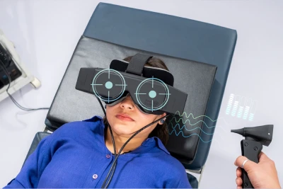 Medical professional demonstrating the use of a diagnostic device for balance or vestibular assessment on a patient.