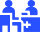 Blue icon depicting two people seated at a table, symbolizing collaboration or discussion